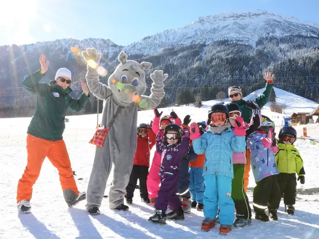Spaß in der Skischule Pfronten im Allgäu Kinder der Skischule jubeln mit dem Maskottchen am Skihang.